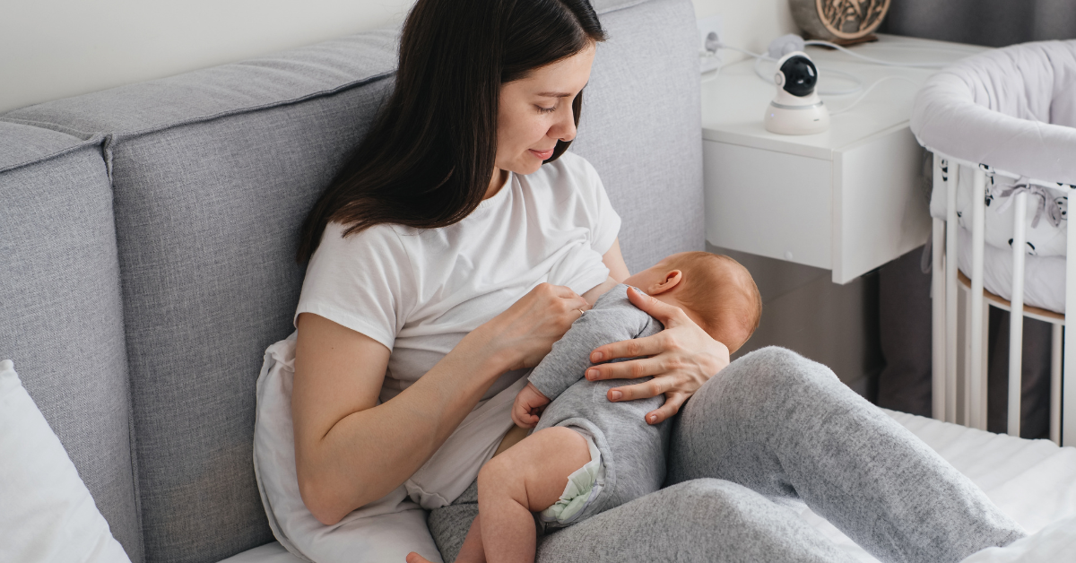 Mama na łóżku karmi piersią